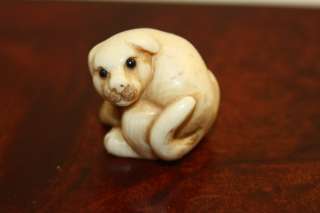 Netsuke of a dog signed by artist in fine condition. 3/4 of an inch by 